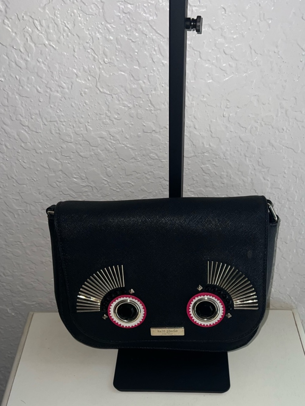 kate spade black crossbody with metallic and pink eyelet accents